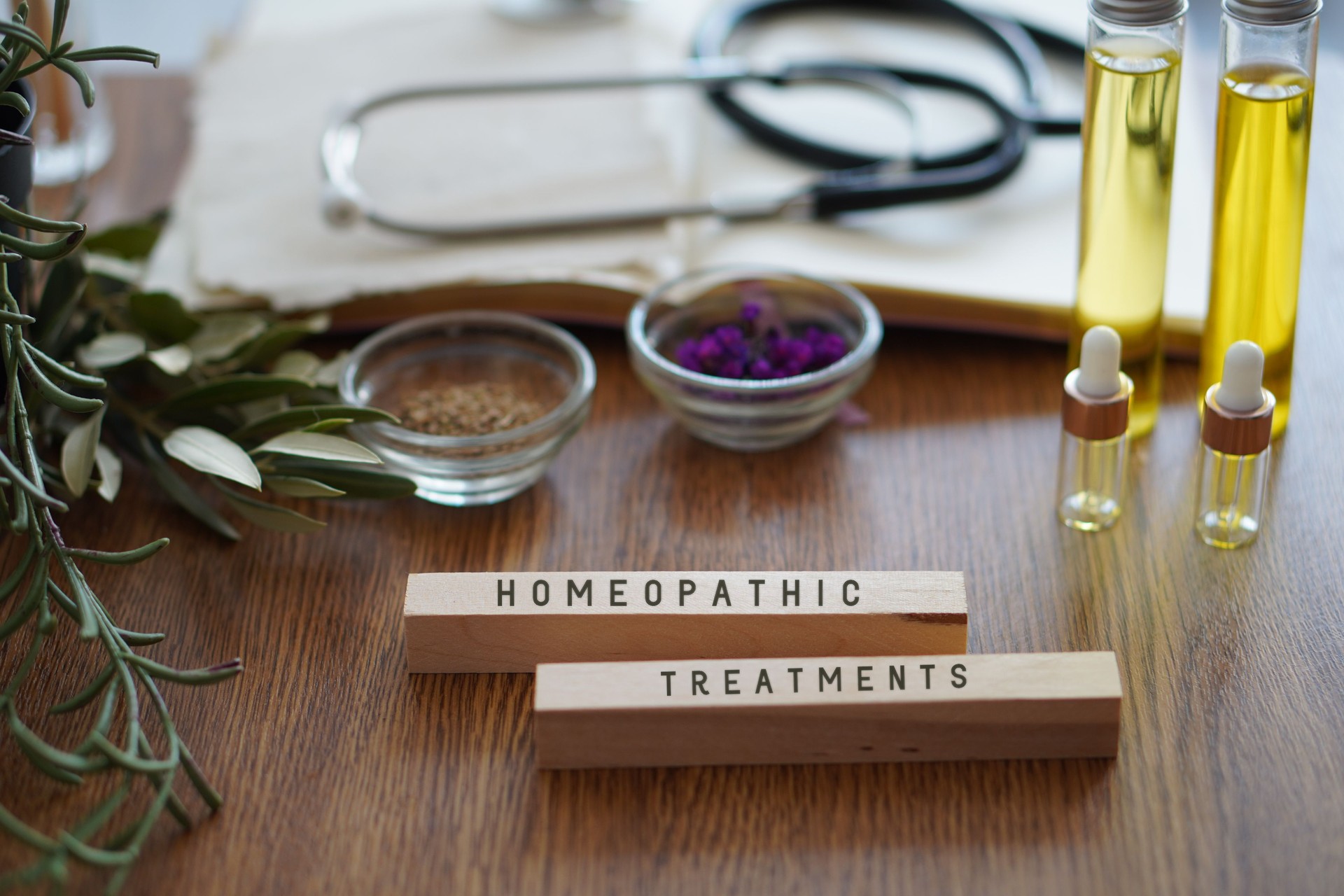 HOMEOPATIC TREATMENTS. table with stethoscope, oils and natural remedies.