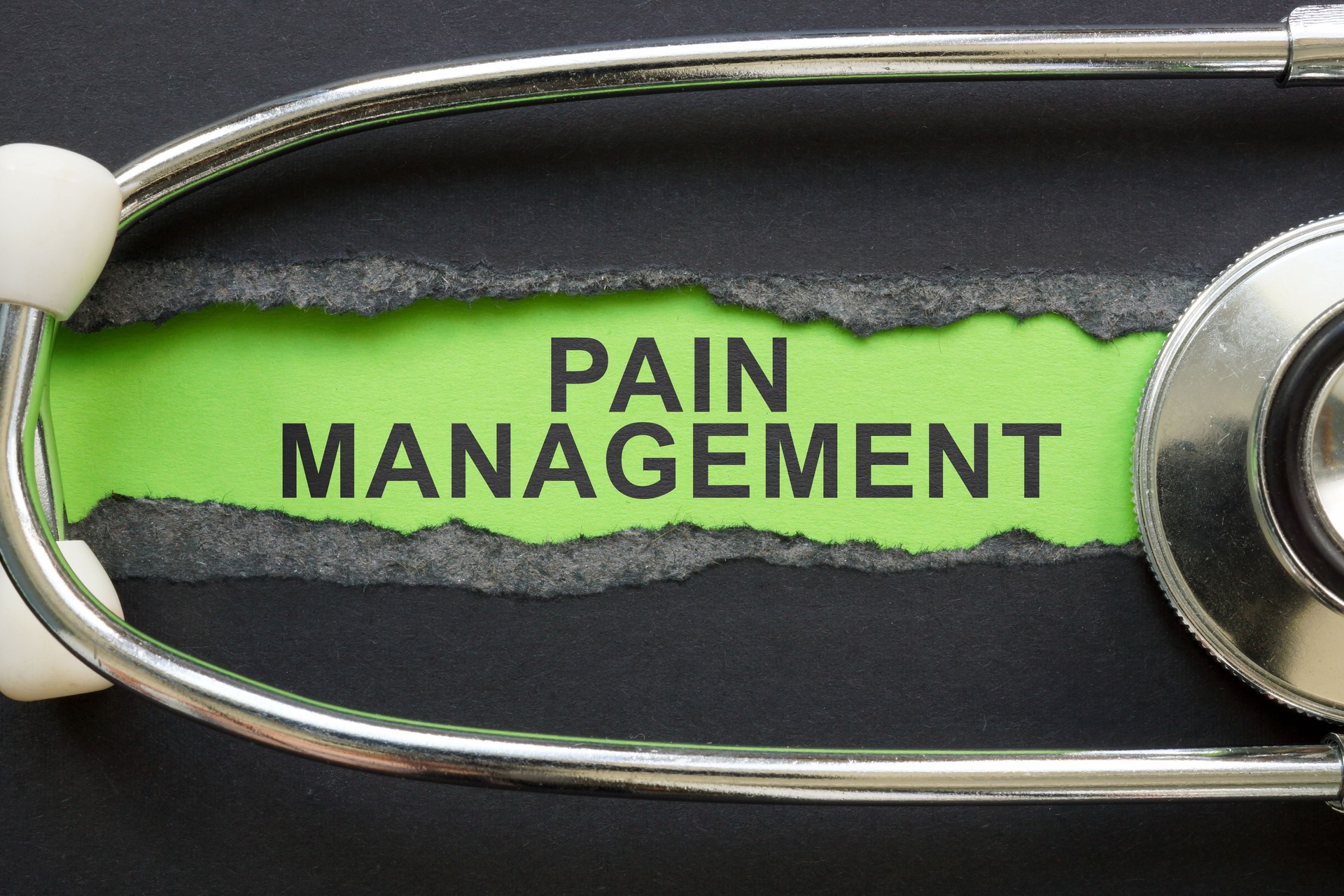 Torn piece of paper with the phrase pain management and a stethoscope. Pain control strategies.